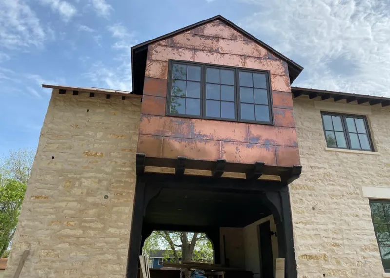 Copper metal panel facade on a stone building for Skylight Installation in Guilford